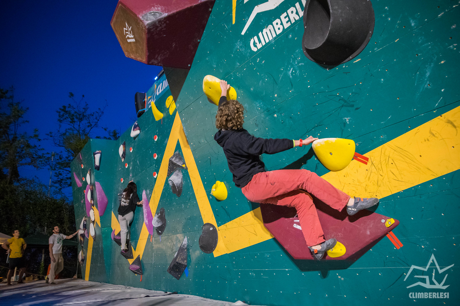 Partecipanti che arrampicano sulla parete boulder del Festival